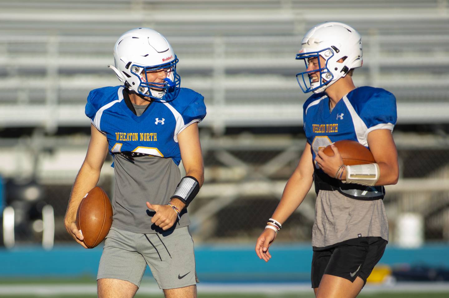 Quarterback Tyler O'Connor, left, talks to quarterback Max Howser during practice at Wheaton North on Thursday, Aug. 11, 2022.