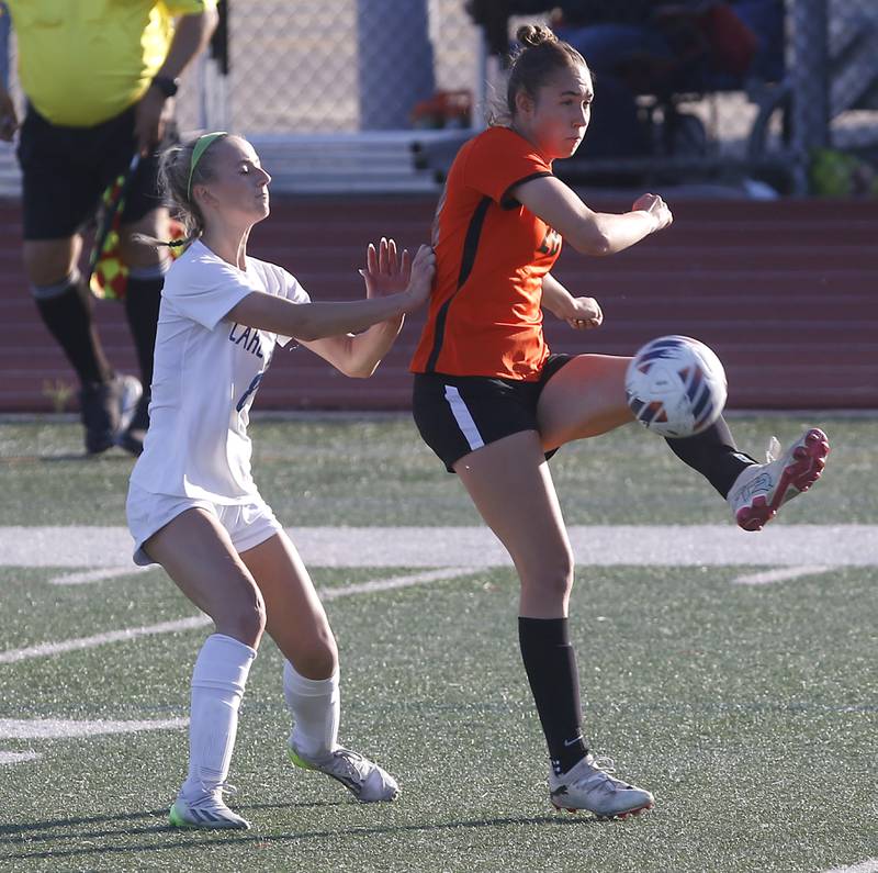 Crystal Lake Central's Jillian Mueller kicks the ball towards the goal as she is defended by Lake Forest's Ava Walsh during a Class 2A Deerfield Sectional semi-final match on Tuesday, May 21, 2024, at Deerfield High School.