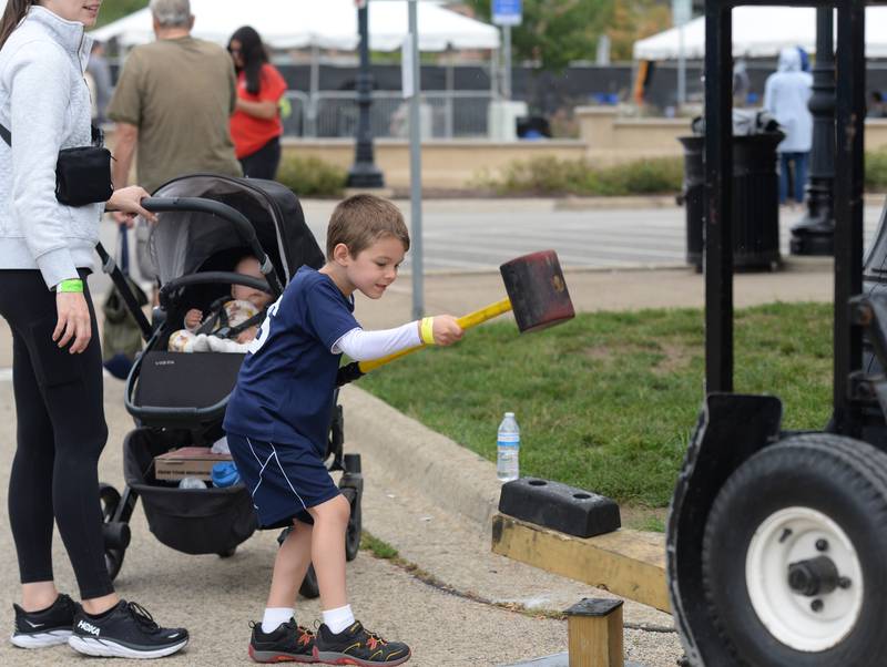 Children and families including James Lenin of Downers Grove test their strength while attending the Downers Grove Octoberfest Saturday, Sept. 16, 2023.