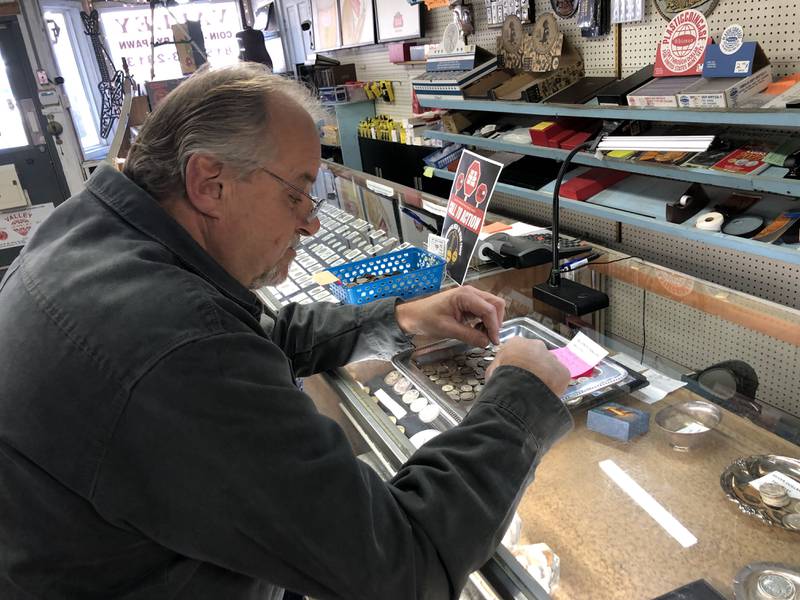 Customer Mike McNeal looks through different types of coins at the Illinois Valley Coin and Pawn shop in Spring Valley on Wednesday, Dec. 28, 2022.