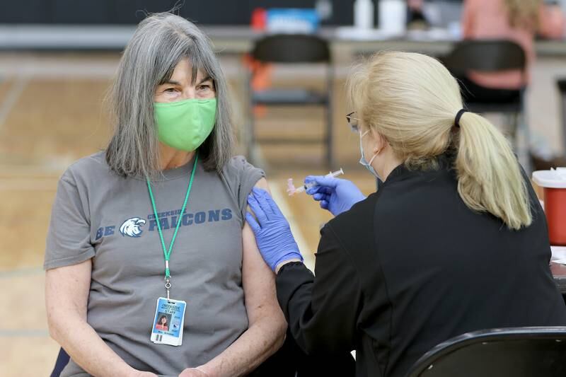 Creekside Middle School associate Marianne Bateman receives her first shot of the Moderna COVID-19 vaccine during a vaccination clinic for staff with Woodstock Community Unit School District 200 and Johnsburg School District 12 at Woodstock North High School on Thursday, Feb. 11, 2021 in Woodstock.  The clinic is hoping to vaccinate 2,600 employees of school districts in the northern half of McHenry County with the Moderna COVID-19 vaccine over the course of Thursday and Friday.