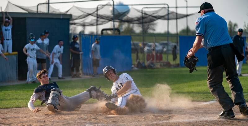 Oswego East's Zachary Polubinski (9) slides into home for a score against Oswego during a baseball game at Oswego East High School on Tuesday, May 10, 2022.