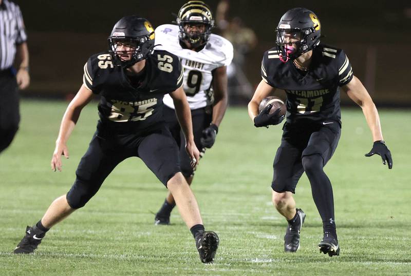 Sycamore's Burke Gautcher follows the blocking of Joey Ward after a catch during their game against Oak Forest Friday Sept. 2, 2022, at Sycamore High School.