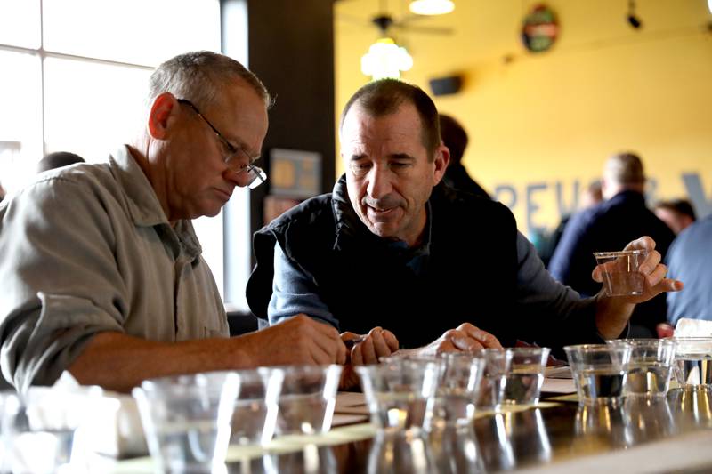 Judges Dan Mann and Paul Young confer during the annual Kane County Water Association's annual water-tasting contest at Global Brew in St. Charles on Thursday, Dec. 21, 2023.