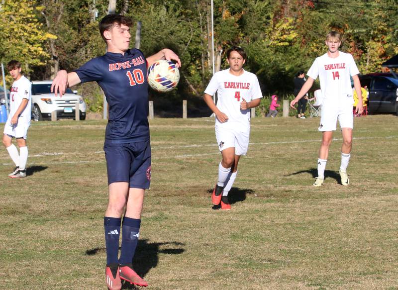 DePue/Hall's Ilan Bardot knocks the ball down as Earlville's Grady Harp and Adin Hensley look on during the Class 1A Regional quarterfinal game on Wednesday, Oct. 16, 2024 in DePue.