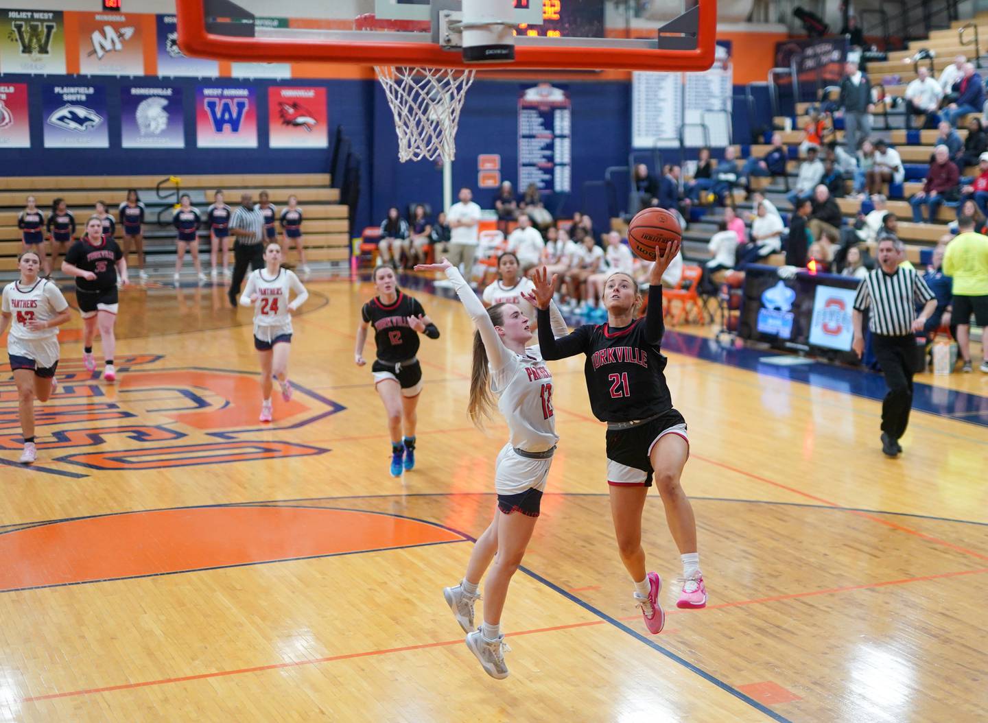 Yorkville's Kenzie Sweeney (21) drives to the hoop against Oswego’s Emily Mengerink (12) during a basketball game at Oswego High School on Saturday, Jan 27, 2024.
