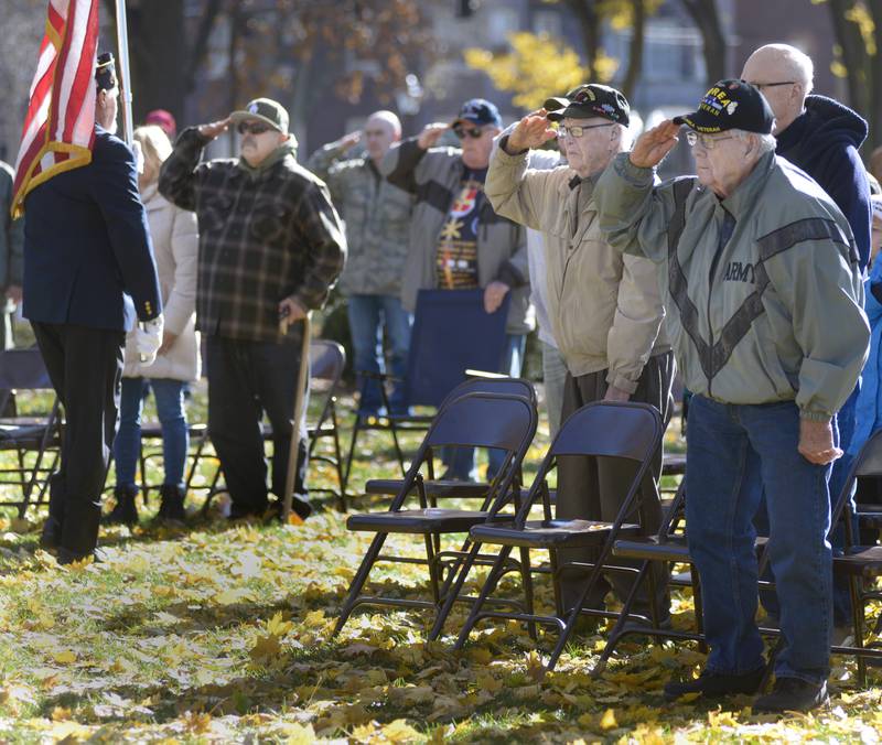 Veterans salute the flag Saturday, Nov. 11, 2023, as it passes during the posting of the colors during the Veterans Day ceremony at Washington Square in Ottawa.