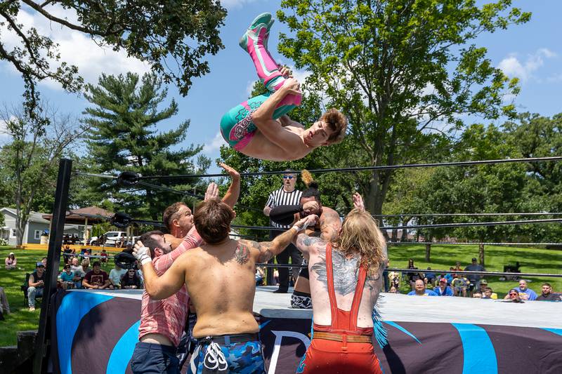 (above) Jake Bosche performs flying cannonball over top rope onto opponents at the Taste of the Illinois Valley DreamWave Wrestling event on Saturday, August 2, 2025 at Centennial Park in Peru.