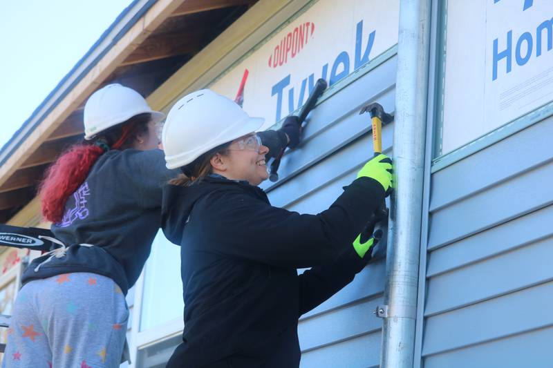 Jade Winkoski (left) Taylor Lupa install siding on the Gonzalez's home Nov. 11, 2023 during the organization's third of three Women Build events in Kingston.