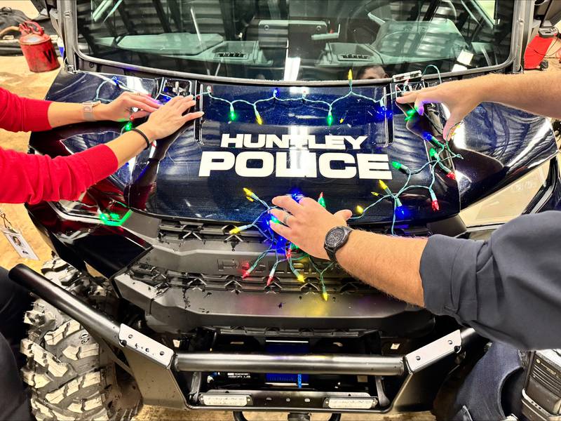 Carly Ritter and Officer Jerry Keppler from the Huntley Police Department decorate department vehicles Wednesday, Dec. 3, 2025, for Saturday's Christmas parade, a newly added part of the Very Merry Huntley holiday celebration. The parade steps off at 5 p.m. Saturday at the intersection of Main and Bakley streets.