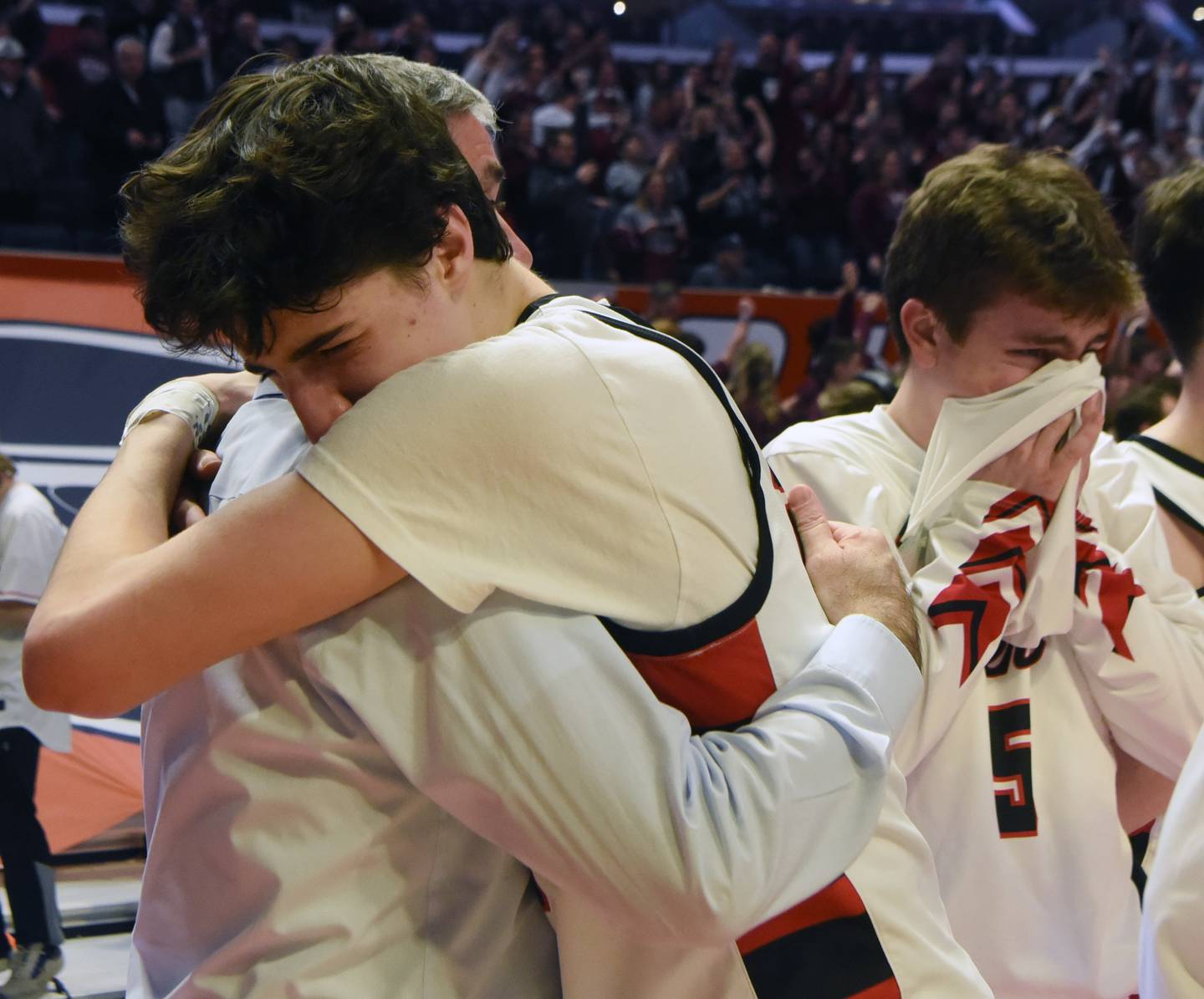 Joe Lewnard/jlewnard@dailyherald.com
Benet Academy's Niko Abusara hugs head coach Gene Heidkamp following their team’s 59-42 loss to Moline during the Class 4A boys basketball state championship at State Farm Center in Champaign Saturday.