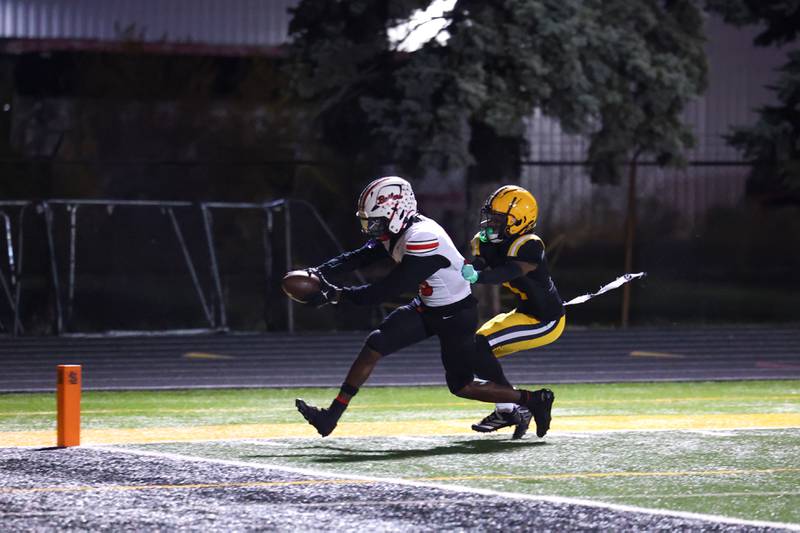 Bradley-Bourbonnais' Lyzale Edmon reaches in for a touchdown ahead of St. Laurence's Mikhail Riley during the Vikings 35-21 victory over Bradley-Bourbonnais in second round playoff on Friday, Nov. 7, 2025.