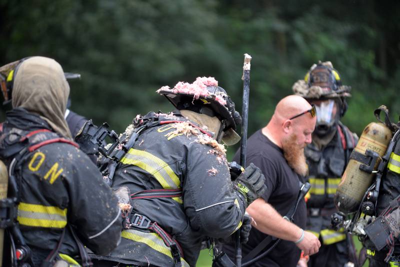 Oregon firefighters have their oxygen tanks replaced while battling a fire at 540 E. Elizabeth Road on Wednesday, Aug. 20, 2025.