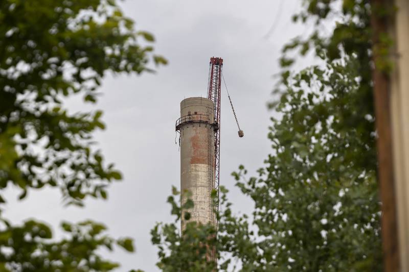 A crane operator works to demolish the 310-foot smokestack at the St. Mary’s Cement plant Monday, July 21, 2025, in Dixon.