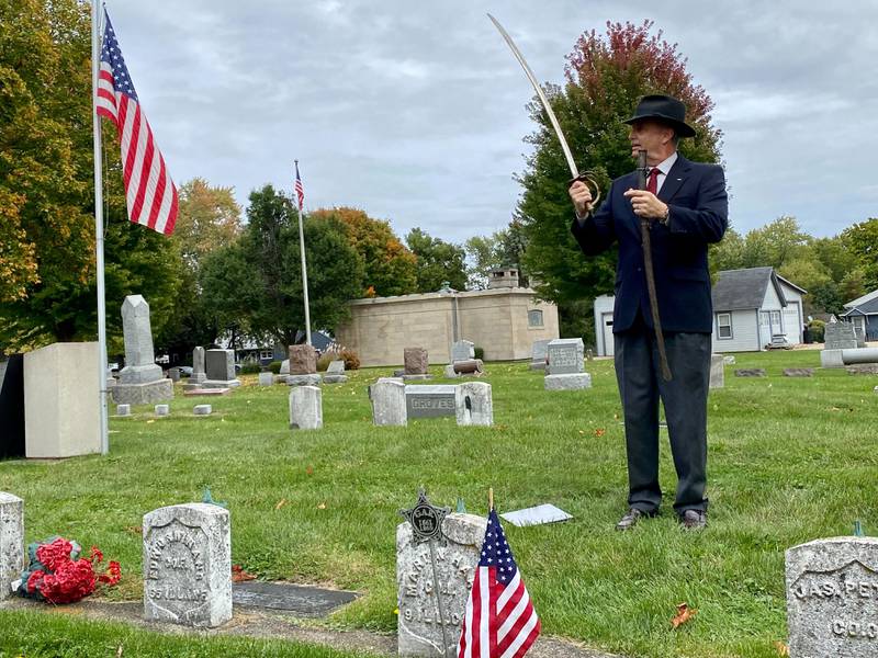 Lars Jacobson, member of the Sons of Union Veterans of the Civil War, presents information on Martin Hare, a Sycamore Civil War veteran who lived from 1837 to 1911, a private corp. who served in the 9th Illinois Calvary. Jacobson displays a calvary saber likely used during combat in the war. Jacobson spoke at the DeKalb County History Center’s annual Etched in Stone Cemetery Walk at Elmwood Cemetery, 901 S. Cross St., Sycamore on Sunday, Oct. 8, 2023.