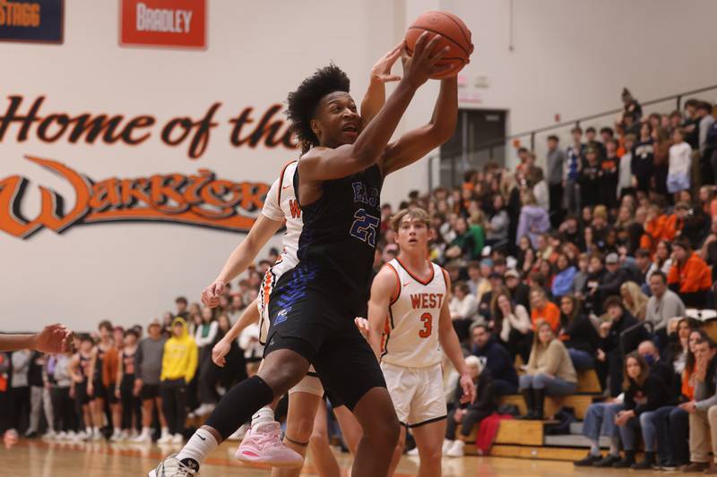 Lincoln-Way East’s George Bellevue grabs the rebound against Lincoln-Way West.