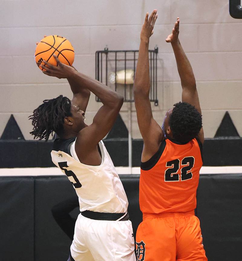 Kaneland's Fredrick Hassan shoots over DeKalb's Justin O’Neal during their game Tuesday, Jan. 28, 2025, at Kaneland High School in Maple Park.
