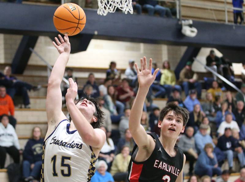 Marquette's Alec Novotney eyes the hoop as Earlville's Easton Fruit defends on Friday, Jan. 3, 2025 in Bader Gym at Marquette High School.