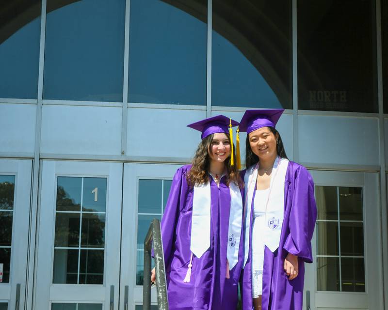 Downers Grove North seniors Lily Enright and Natalie Lamar pose in front of the school on Sunday May 19, 2024, before the start of the graduation ceremony held at Downers Grove North High School.