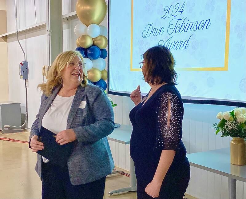 Genoa-Kingston School District 424's Stefanie Hill (left), reacts next to Genoa Area Chamber of Commerce executive director Krissy Johnson after Hill was presented with the 2024 Dave Tobinson Award on Thursday, Feb. 13, 2025, at the chamber's 68th Annual Meeting and Awards Dinner at Custom Aluminum Products, 312 Eureka St., Genoa.