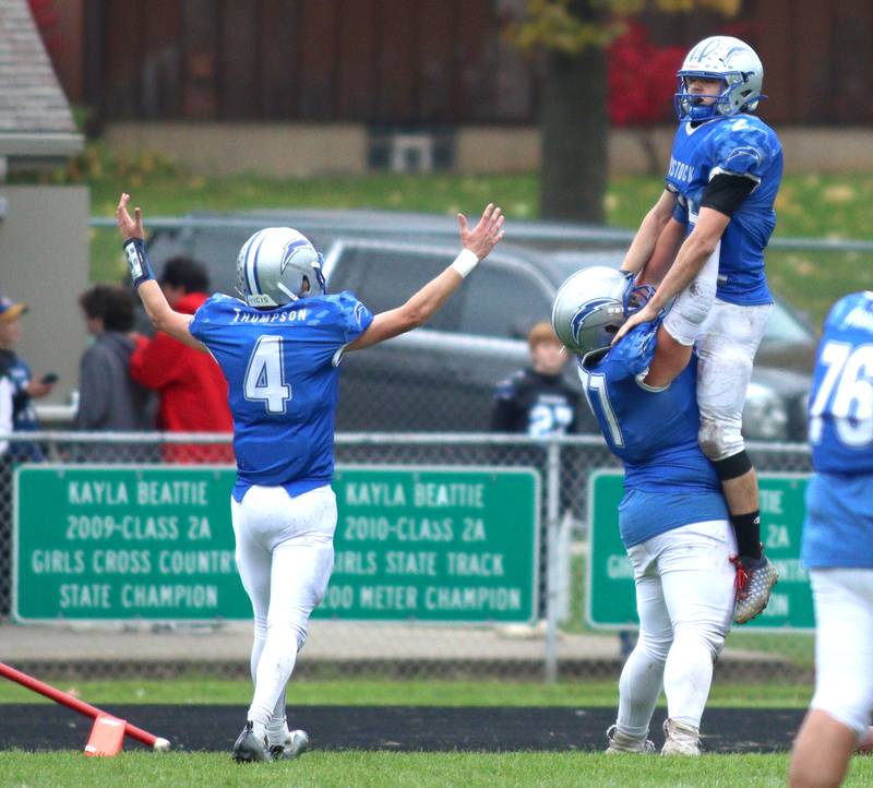 Woodstock’s Maximus Miller, right, gets a lift from Bode Pedersen after a lengthy Miller touchdown run in the fourth quarter against Ottawa in varsity football at Larry Dale Field on the campus of Woodstock High School Saturday.