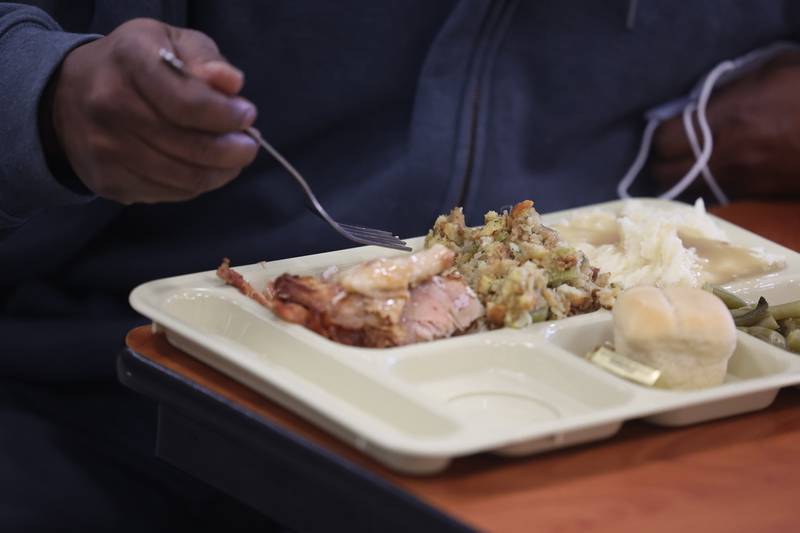 A member of the community eats a Thanksgiving meal at the Daybreak Center on Thanksgiving Day in Joliet.