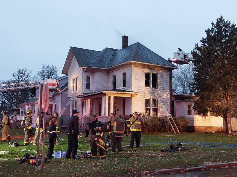 Firefighters hose down the second floor of a house Monday, Nov. 20, 2023, on the corner of Bloomington and Washington streets.