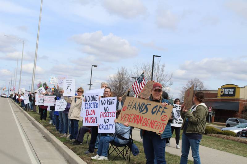 Protesters display their handmade signs during the "Hands Off" protest along Randall Road in Algonquin on April 5, 2025.