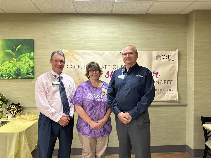 (From left) Scott Hartman, vice president of Support Services, stands with Jereen Mercer, occupational therapy assistant and 2024 Sunflower Award winner, and Jim Scarpaci, manager of Rehabilitation Services at OSF Saint Clare after Mercer received the annual award.
