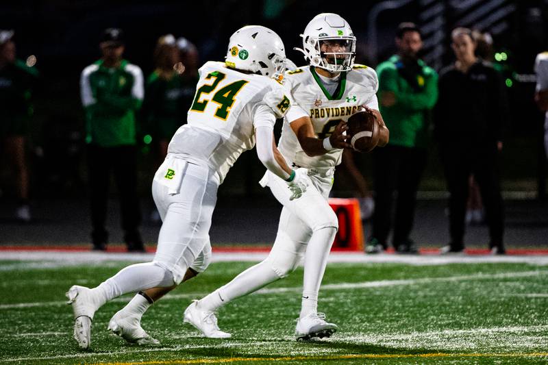 Providence's Dominic Vita hands the ball off to Broden Mackert during a game against Lincoln-Way Central on Friday Sept. 5, 2025 at Lincoln-Way Central High School in New Lenox
