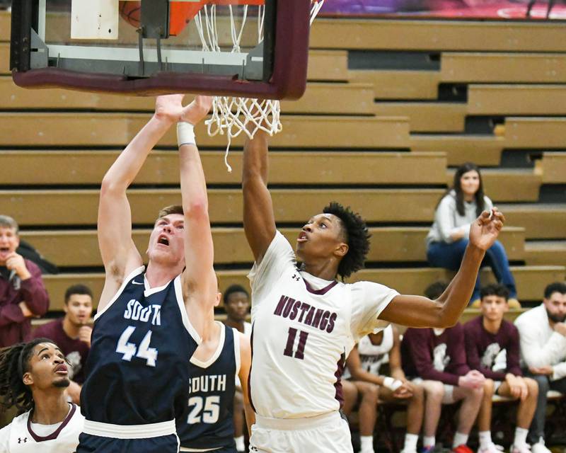 Downers Grove South's Justin Sveiteris (44) goes up for a shot in the first quarter while being defended by Morton East's Tyler Nichols (11) during the game on Saturday Dec. 9, 2023, held at Morton East. High School.