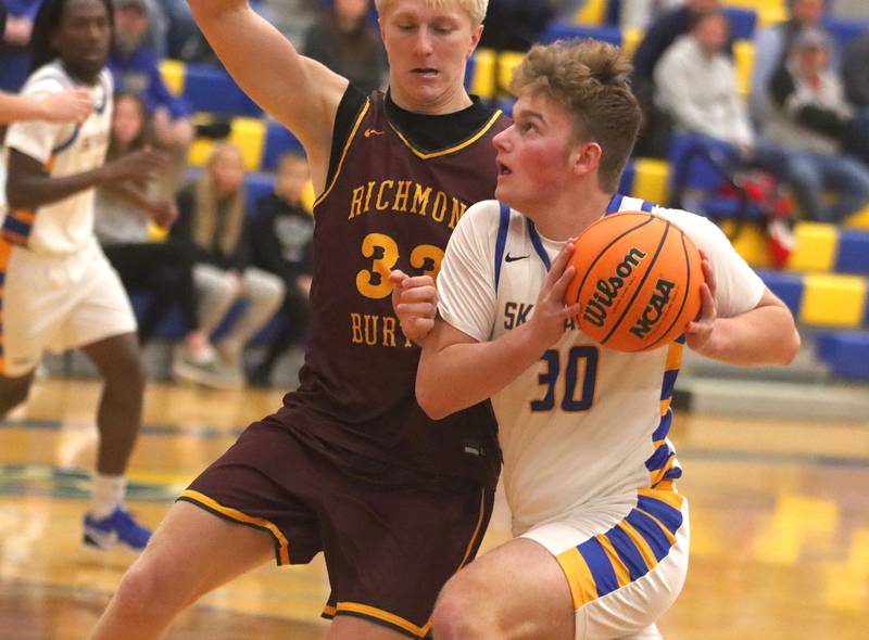 Richmond-Burton’s Luke Robinson, left, guards Johnsburg’s Jayce Schmitt in varsity boys basketball onTuesday, Dec. 9, 2025, at Johnsburg High School in Johnsburg.