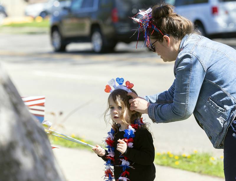 Jinny Swedberg of Dixon sets a patriotic headdress on daughter Eliza, 4, Saturday, April, 26, 2025, as the two wait for the start of a Vietnam veteran parade.