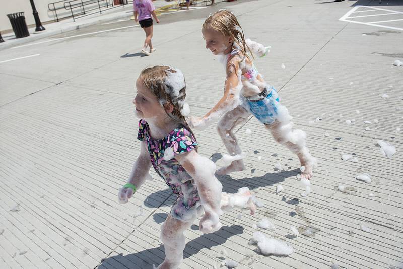 Laikyn (left), 4, and Emersyn Assenmacher, 8, race for the sudsy pool party Saturday, July 30, 2022 during Morrison’s Shuckfest. The sweet corn centered festival is the first for the town.