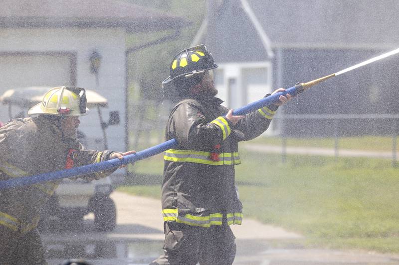 Tampico firefighters concentrate their hoses on a sliding bucket during a water fight Saturday, July 22, 2023 during Tampico Days. The competition pitted firefighter vs firefighter to see who could move the bucket to the opponent’s end zone.