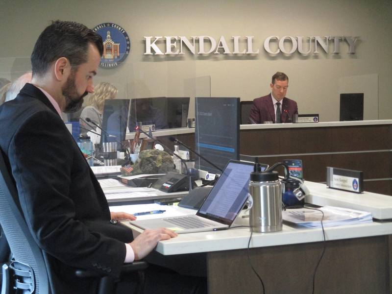 Kendall County Board Chairman Scott Gryder, right, presides over the March 15, 2022 board meeting as County Administrator Scott Koeppel, foreground, follows business on his screen. (Mark Foster -- mfoster@shawmedia.com)