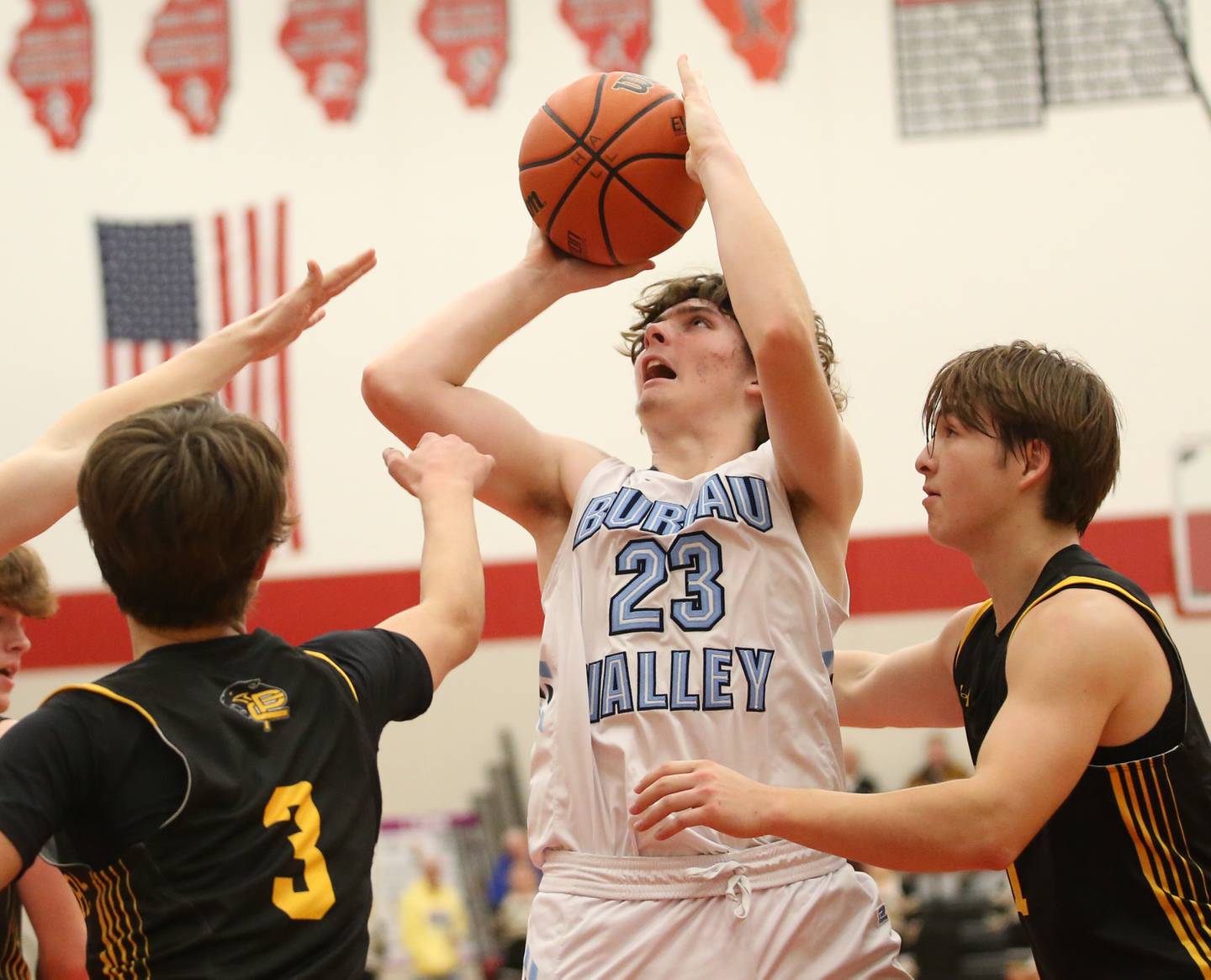 Bureau Valley's Landen Birdsley eyes the hoop while being guarded by Putnam County's Bryce Smith and teammate Owen Saepharn during the 49th annual Colmone Class on Thursday, Dec. 7, 2023 at Hall High School.