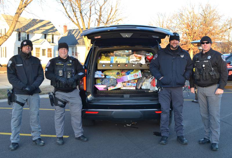 Officer Benjamin Eshelman, Sgt. Dwayne Hamilton, Police Chief Nick Neblung, and Officer Chad Hermes, from left, braved the cold temperatures on Saturday, Dec. 3 to collect toys and cash donations for the Fulton Police Department’s 2nd annual Toy Drive at First Christian Reformed Church. Thanks to the generosity of the community, they were able to fill one and half squad cars with toys while also raising $3,022 to purchase more gifts. All toys and donations will be distributed to kids and families in the River Bend School District.