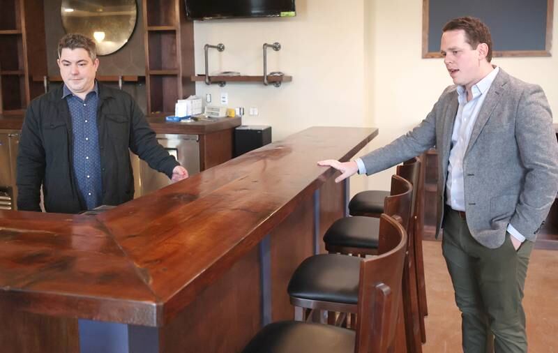 The Grove restaurant and bar owners Jason Engstrom (left) and Sam Patterson talk about the reclaimed barn wood that was used to create the bar Thursday, March 23, 2023, during a tour of the new eatery in DeKalb. They plan to open their doors upon completion within the next few weeks.