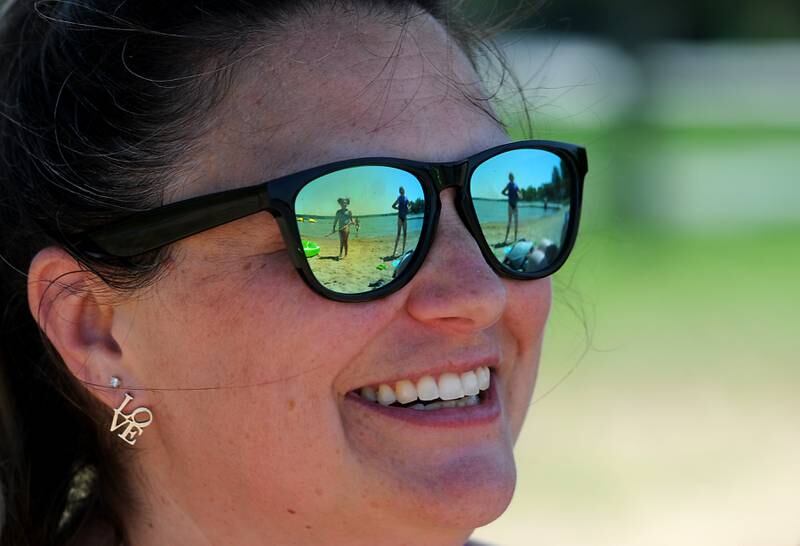 Becky Amos smiles as her daughter Tessa, 7, approaches with a water-squirting toy on Tuesday, June 14, 2022, while at Petersen Park Beach, as temperatures in the McHenry County area reached the mid-90’s.