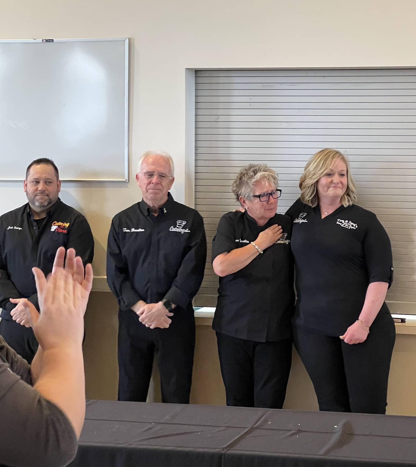 Josh Osenga, married couple Diann Beaulieu and Tom Beaulieu, and Sarah Meyer – the people behind Tom & Jerry’s and Catering by Diann – tear up as hundreds give them a standing ovation on March 5, 2026, during the 109th Sycamore Chamber of Commerce annual meeting.