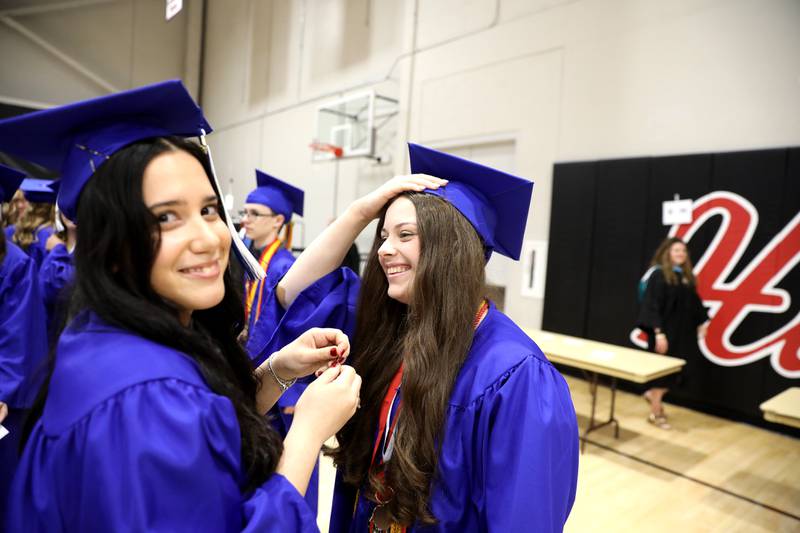 Geneva High School graduate Toula Vitsentzatou (left) fixes the cap of classmate Angelina Turner (right) before the school’s 2024 commencement ceremony at Northern Illinois University in DeKalb on Tuesday, May 28, 2024.