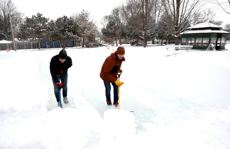 Sugar Grove Park District employees Chris Nesterowicz (left) and Scott Nadeau clear snow from the ice rink on Friday, Jan. 10, 2025 behind the Sugar Grove Township Community Building. The rink, which is possible through a partnership between the Sugar Grove Park District, Sugar Grove Township Sugar Grove Fire Protection District and Village of Sugar Grove,  is frozen and ready for skaters.