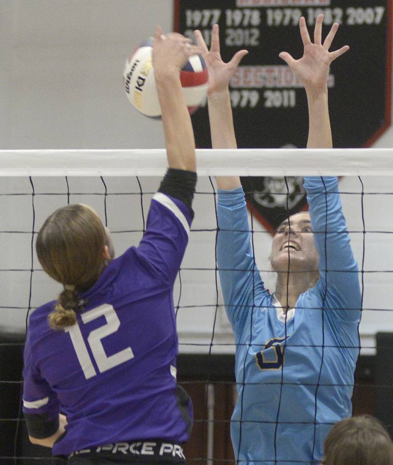 Marquette’s Mary Lechtenberg sets to block a hit by Lexington’s Eva McCue during the 2nd set Tuesday at the Woodland Sectional.