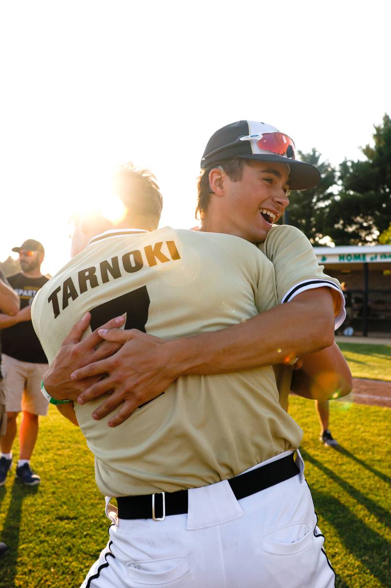 Sycamore's Kiefer Tarnoki (7) and Robbie Guzinski (3) embrace as they celebrate defeating Rock Island, 8-0, in an Illinois Class 3A super-sectional, Monday, June 5, 2023, in Geneseo.during the seventh inning of an Illinois Class 3A super-sectional, Monday, June 5, 2023, in Geneseo.
