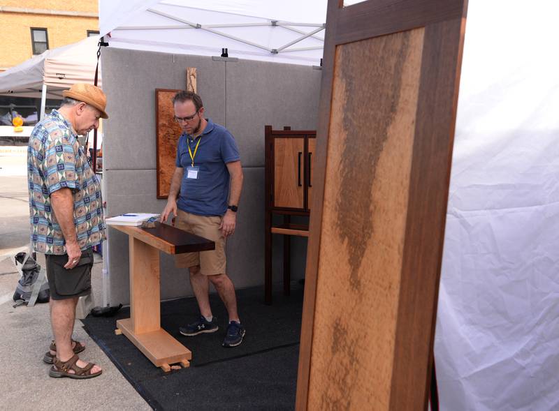 Mike Bremer of Clarendon Hills (left) discusses the wood  making of artist Christian Brokered of Wauconda during the West End Arts Festival in LaGrange Saturday, Sept. 21, 2024.