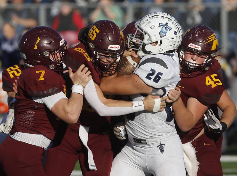 Richmond-Burton's Blake Livdah, Trevor Szumanski, and Riley Shea tackle Monmouth-Roseville's Elijah Noel during an IHSA Class 3A quarterfinal playoff football game on Saturday, November 15, 2025, at Richmond-Burton High School, in Richmond.