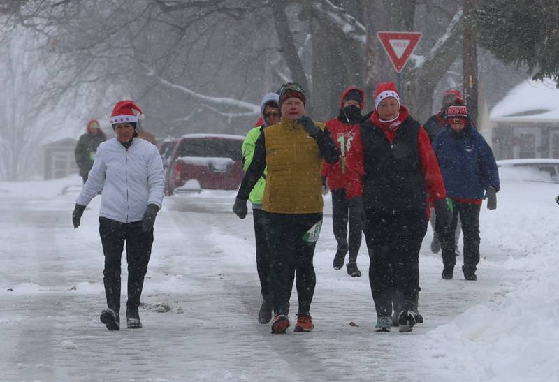 Walkers make their way down 5th Street during the Santas on the Run 5K and one-mile walk on Saturday, Nov. 29, 2025 in Spring Valley.