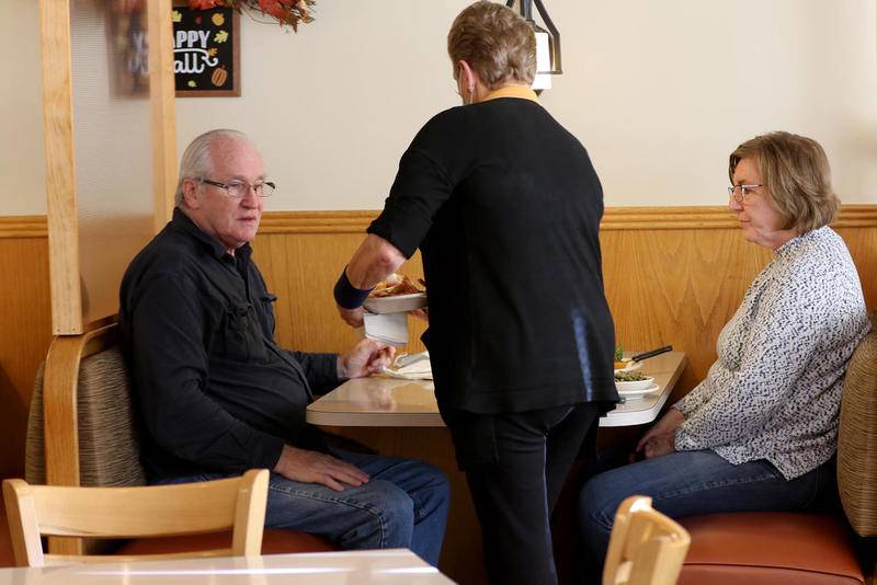 Mary Kotecki delivers food to Garon Albrecht and Arlene Zajdel on Friday at Andy's Restaurant in Crystal Lake. The restaurant will celebrate 40 years in business next year if it is able to overcome the hardships caused by the COVID-19 pandemic, made more difficult by a failed effort by 37 local restaurants to get an immediate injunction against new indoor dining closures.