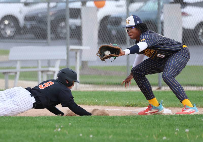 DeKalb's Ryan Duffy dives back into first safely as Neuqua Valley's Christian Lott takes the throw Tuesday, May 5, 2026, during their game at DeKalb High School.